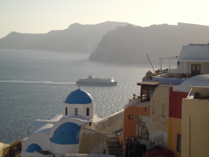 Blue-domed church and white houses above the caldera in Santorini
